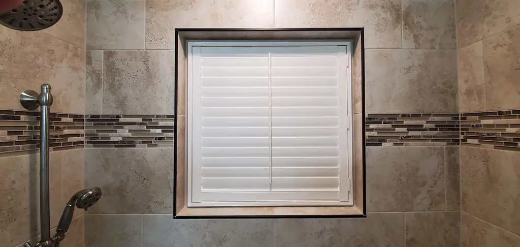 Waterproof plantation shutters fitted inside a tiled shower surround