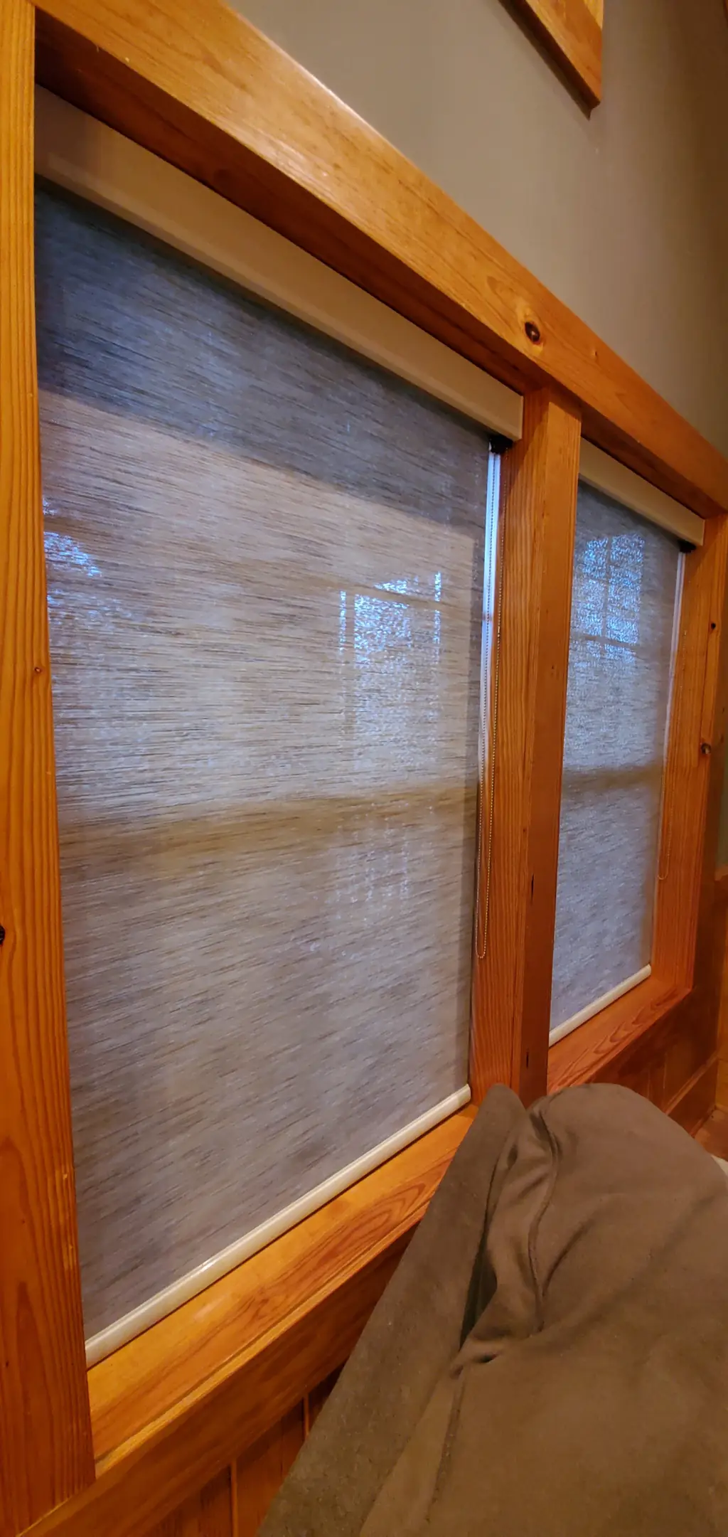 Solar shades filtering afternoon light in a knotty pine cabin room